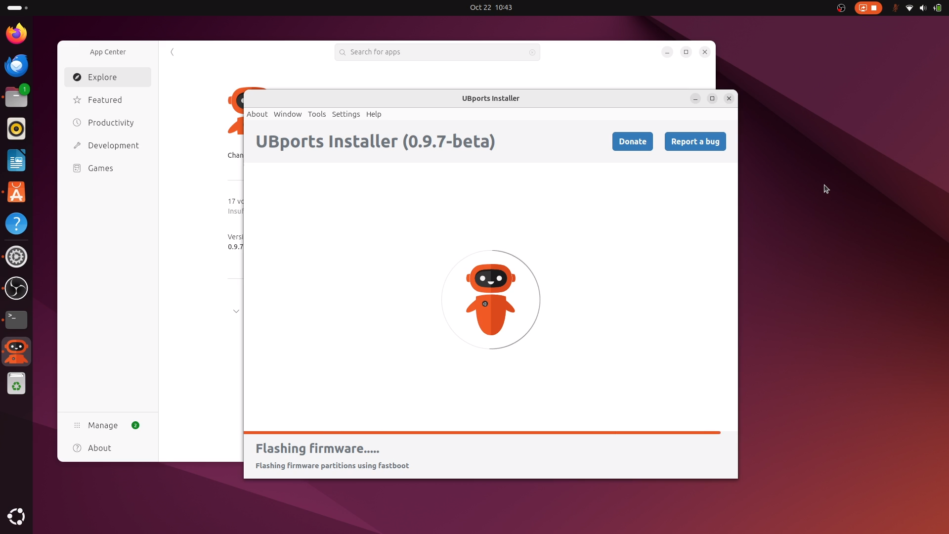 A laptop showing the UBports Installer running and flashing firmware.